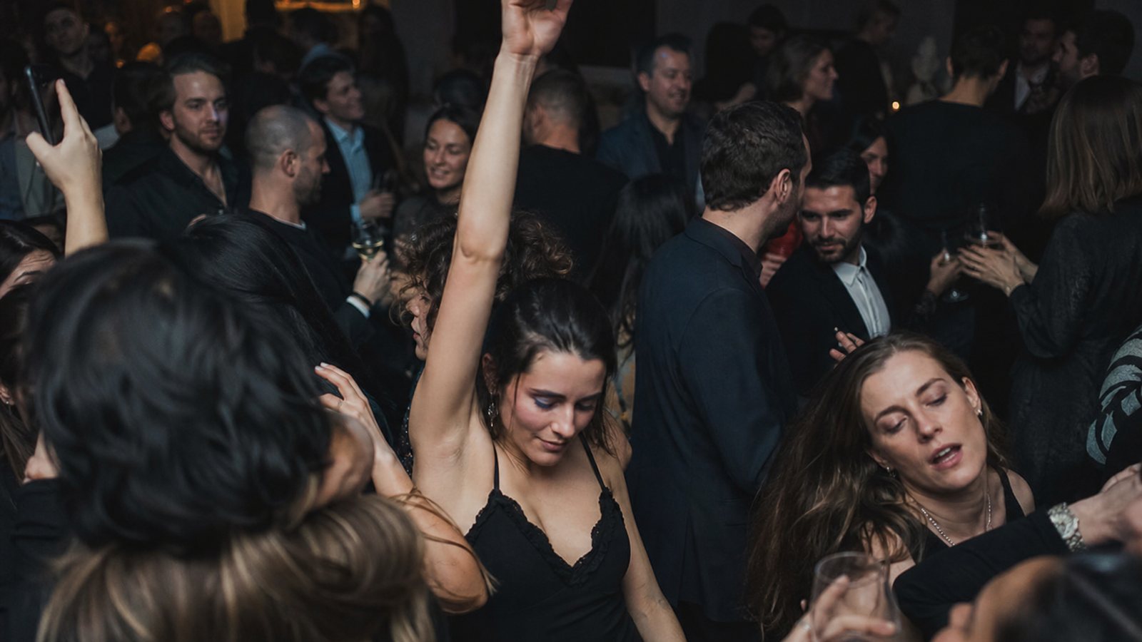 DJ consultant l'heure sur sa console alors que la piste de danse reste pleine en fin de soirée